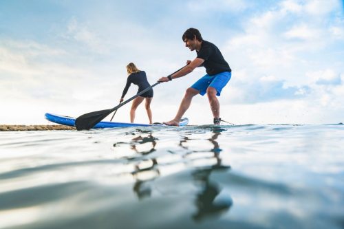 Woman and man competing with paddlesurf in spain